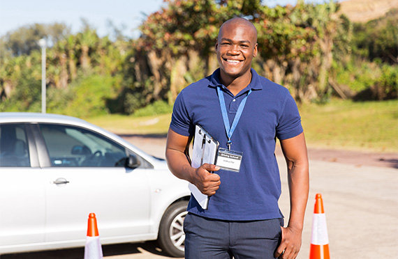 smiling driving instructor holding a clipboard